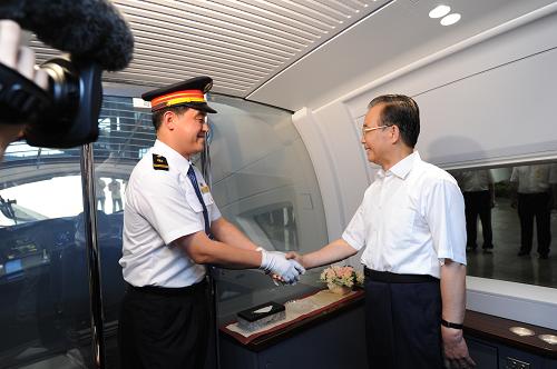 这是温家宝总理在发车前与京沪高铁首发列车驾驶员握手。 6月30日,京沪高速铁路全线建成通车,江南平台入口
总理温家宝出席通车运营仪式并乘首发列车考察运营情况。 新华社记者 王晔 摄