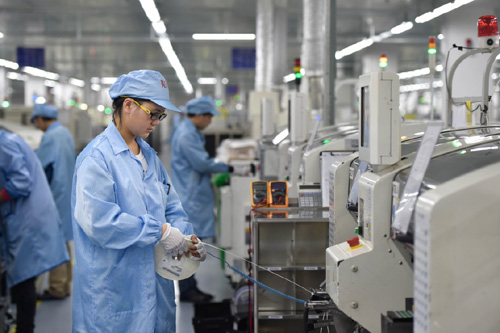 1月19日，在冠捷集团福建福清厂区，工作人员在流水线上操作自动化集成电路贴片机。
