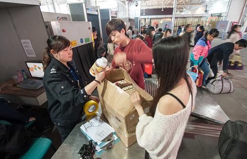 4月4日,重庆火车北站进站口的安检员在对旅客随身携带的行包内的不明物品进行开箱检查。新华社记者 刘潺 摄