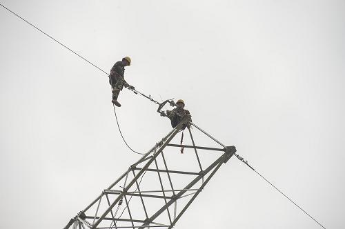 4月22日,在重庆市荣昌县,工作人员在高空安装相关设备。新华社记者 陈诚 摄